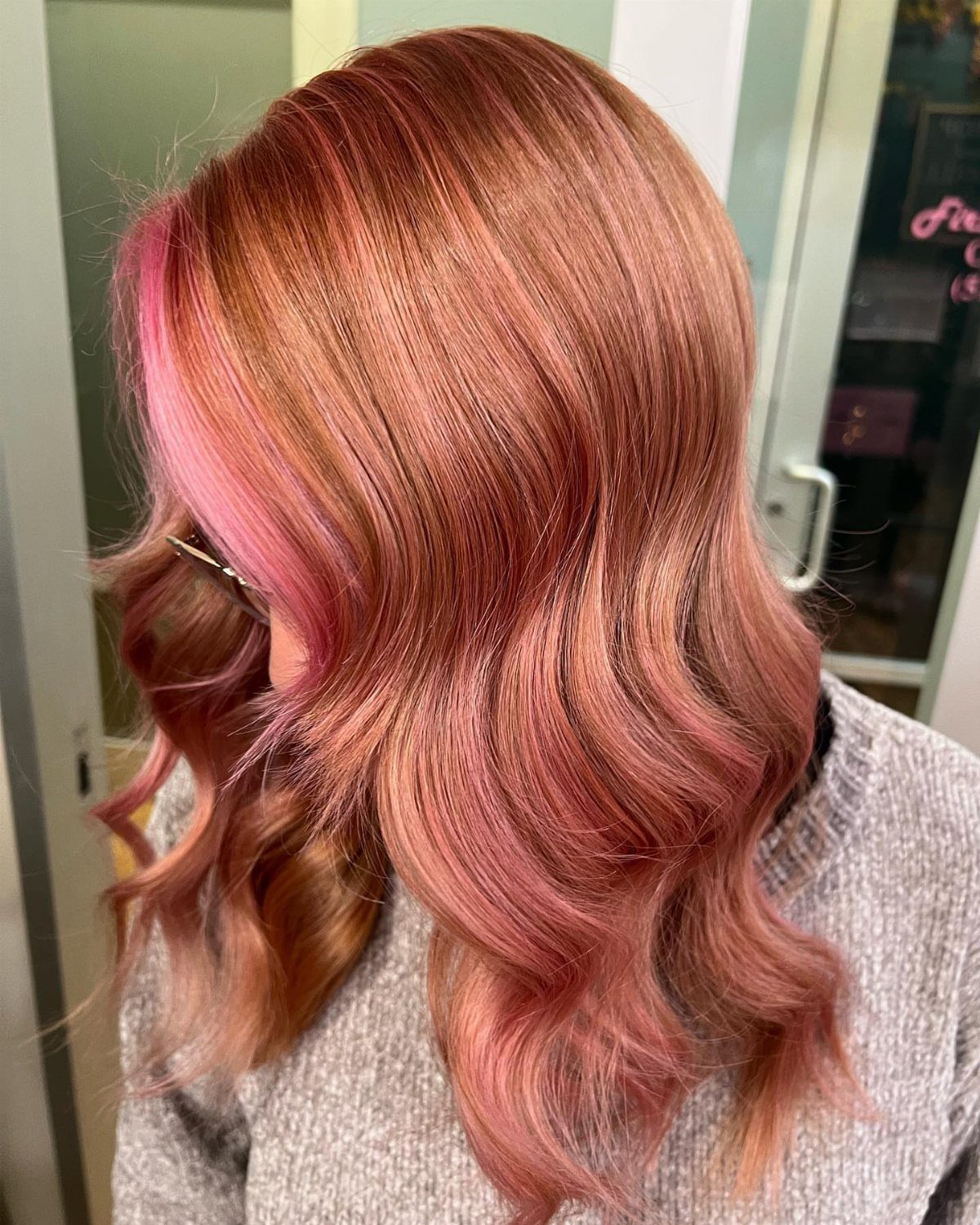Copper and peachy-pink highlighted curls on long, layered hair