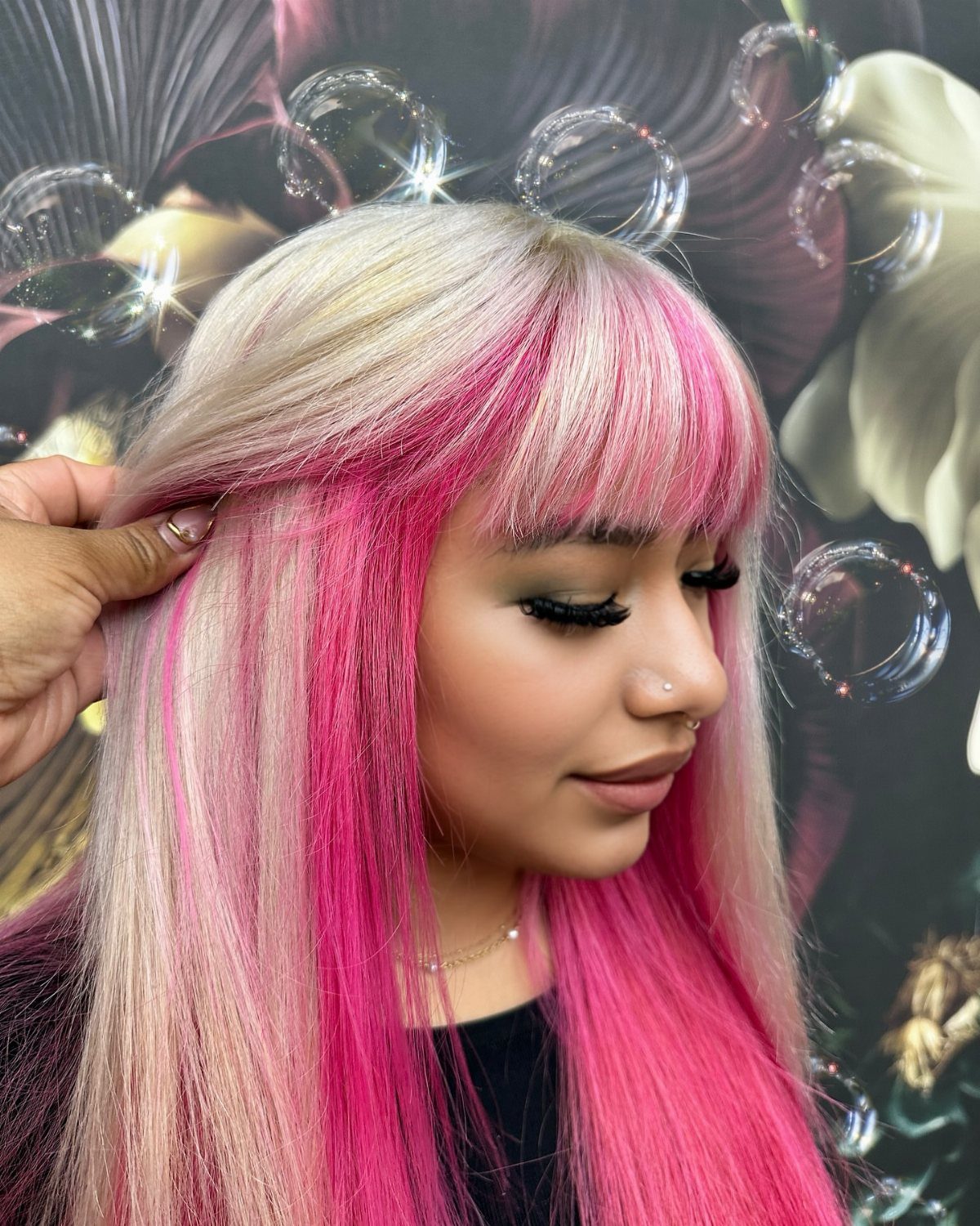 Blonde-haired person showing vivid magenta face-framing highlights in profile