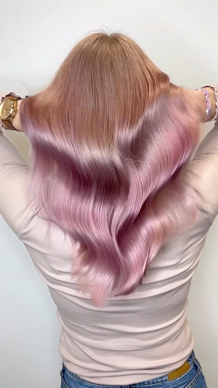 Long wavy blonde hair fades into soft pastel pink lengths