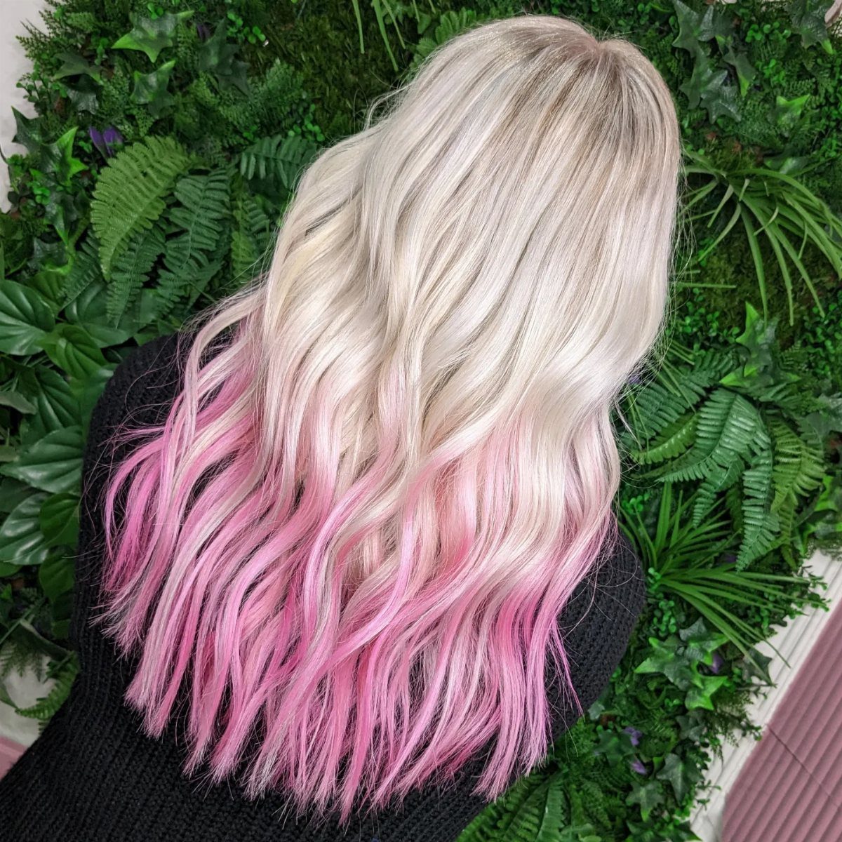 Wavy blonde hair with pastel pink dye concentrated at the tips
