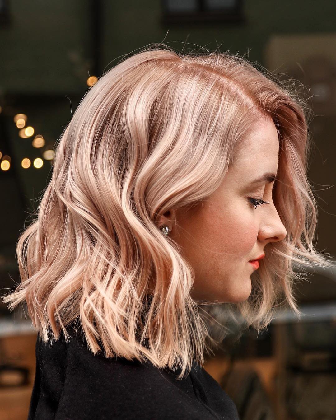 Wavy peach-blonde bob with pastel pink pieces shown in side profile