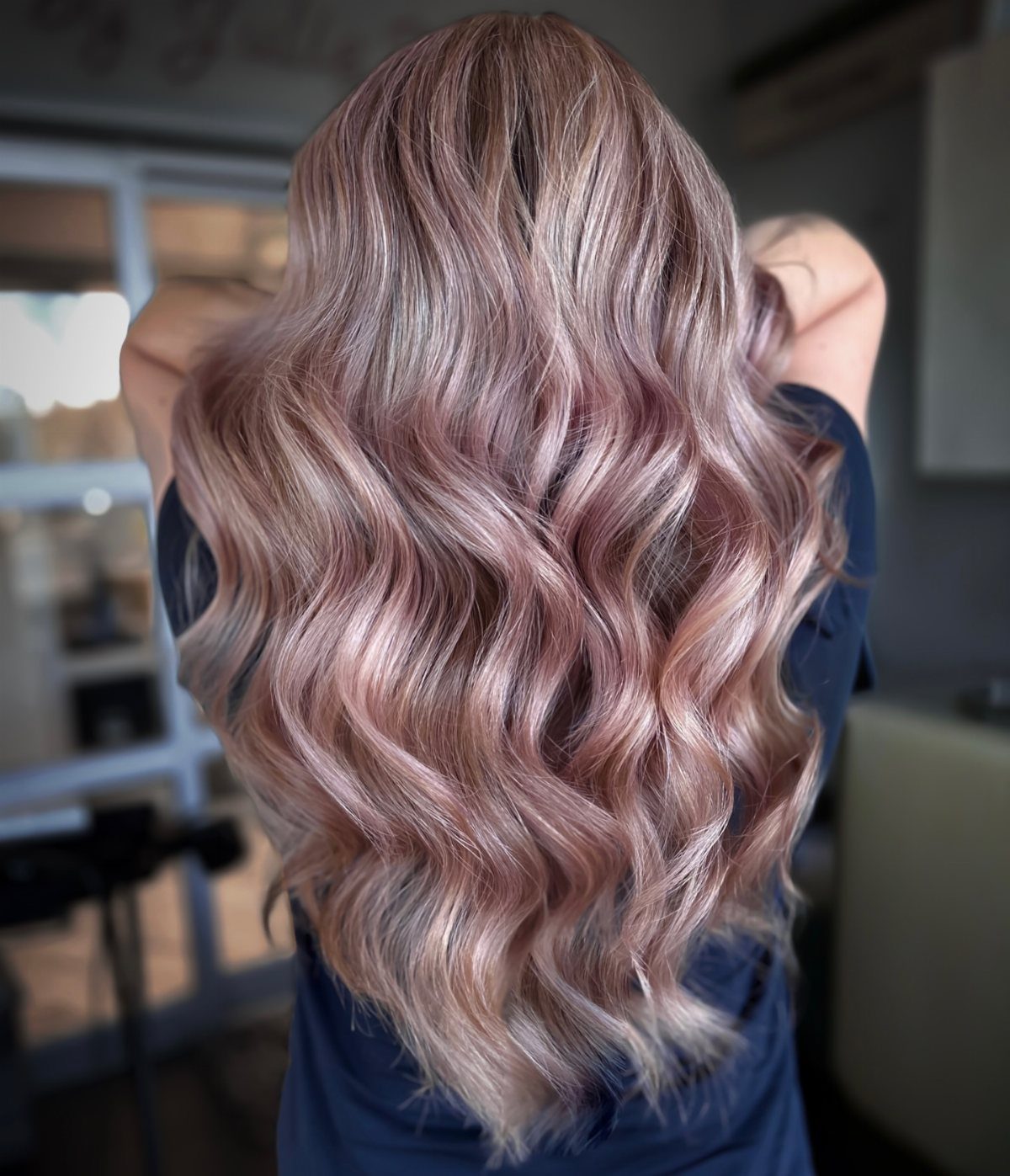 Long wavy hair blends dusty pink and pale blonde tones