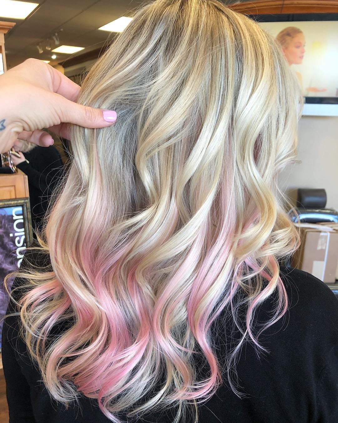 Blonde curls blend into soft bubblegum pink ends in a salon