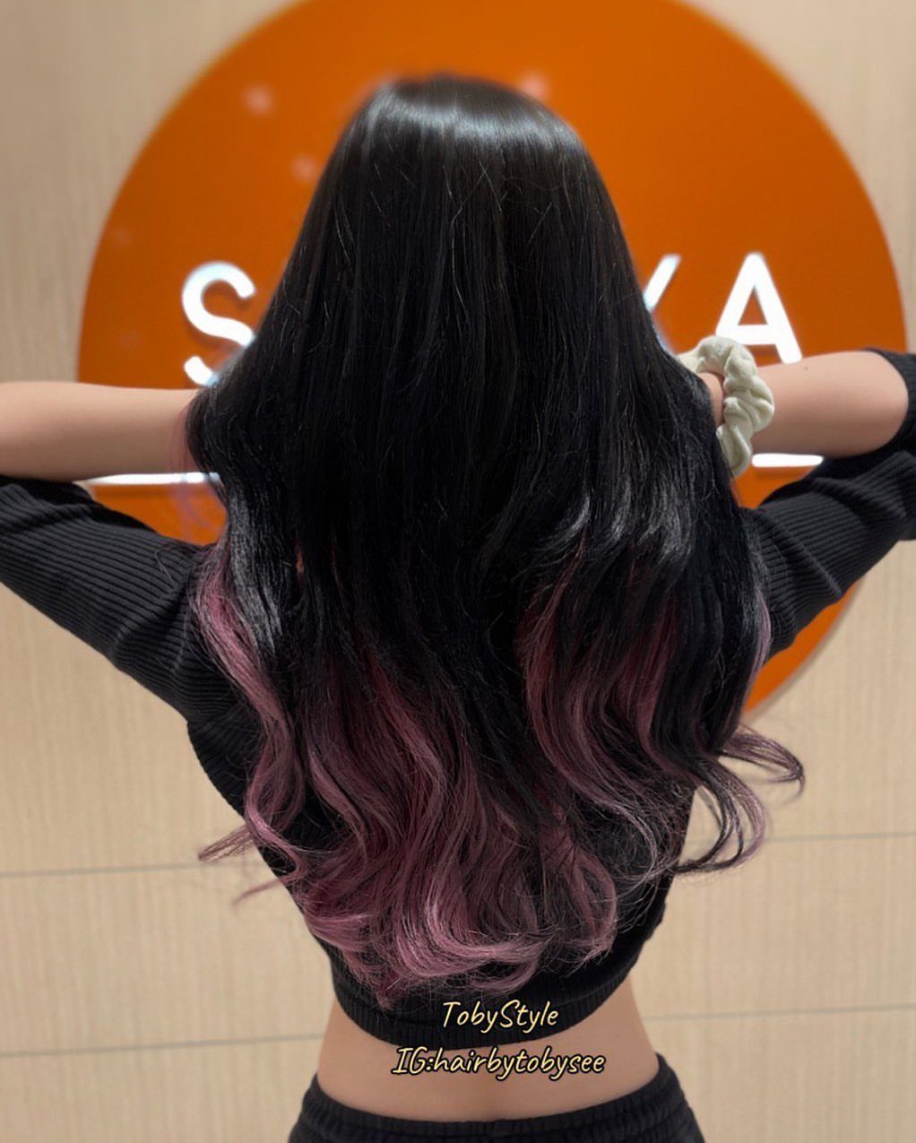 Long black hair with heavy burgundy pink highlights cascading through curled ends