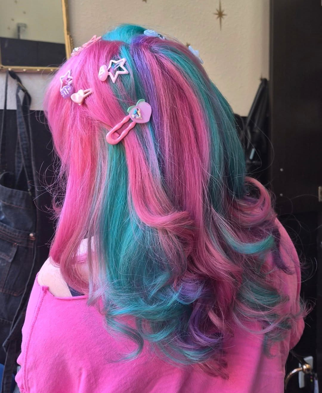 Pink and turquoise split-dyed waves with decorative clips, viewed from behind