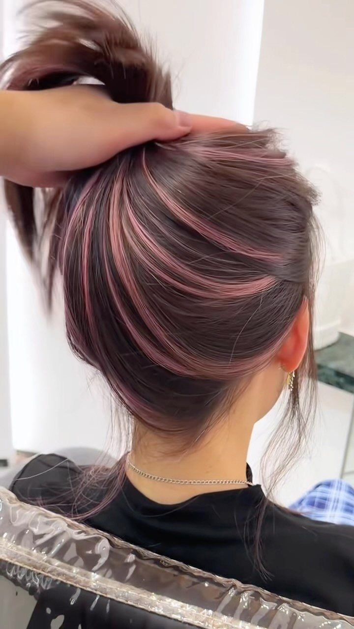 Dark updo with delicate rosewood-pink highlights visible through swept hair