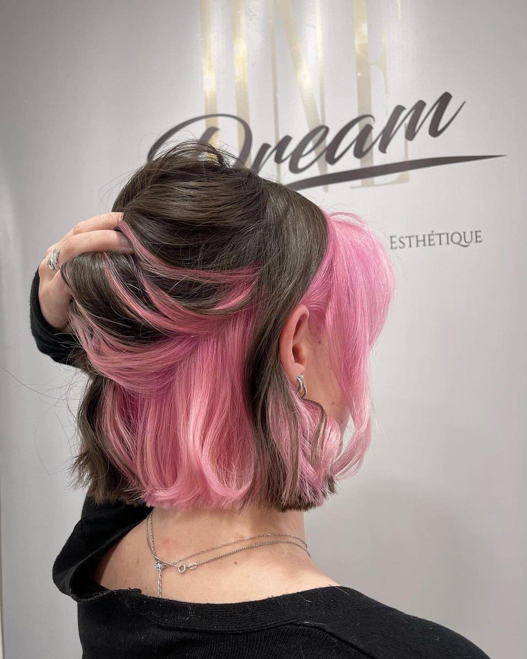 Dark brown bob lifted to reveal vivid pink underlayers and side section