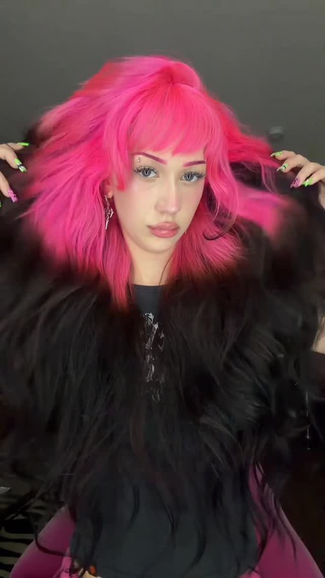 Person displays vivid neon hot pink hair with blunt bangs