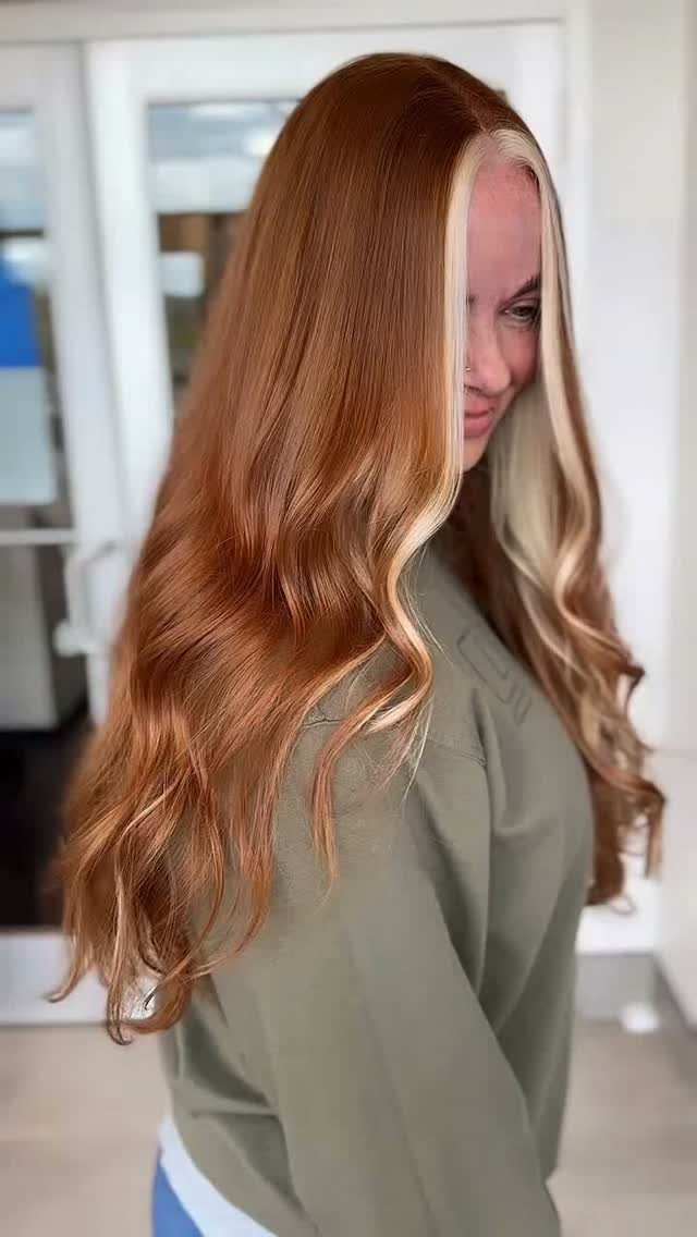 Woman showing wavy auburn hair with contrasting blonde money-piece highlights