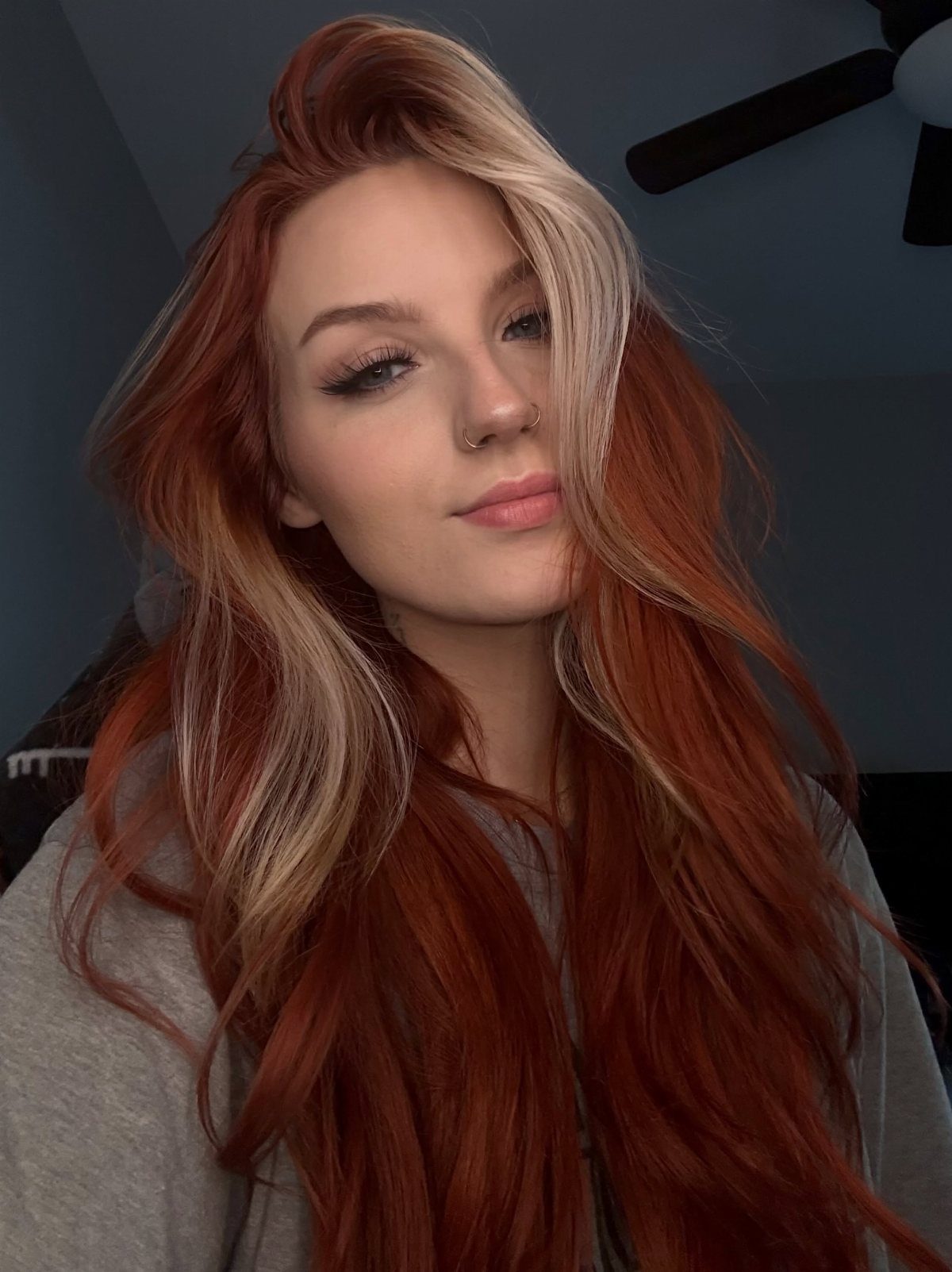 Woman with long red hair and prominent blonde face-framing highlights