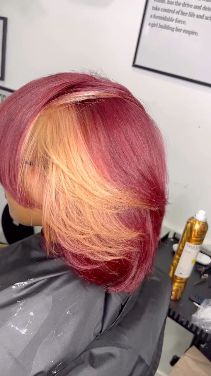 Mannequin head showing cherry-red hair with buttery blonde pieces across the fringe