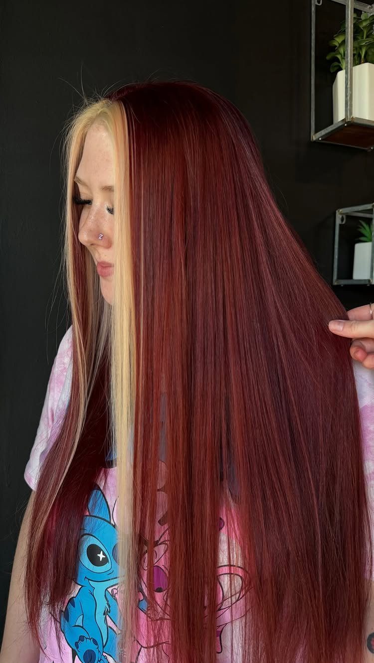 Long chestnut-red hair with wide blonde money-piece sections framing the face