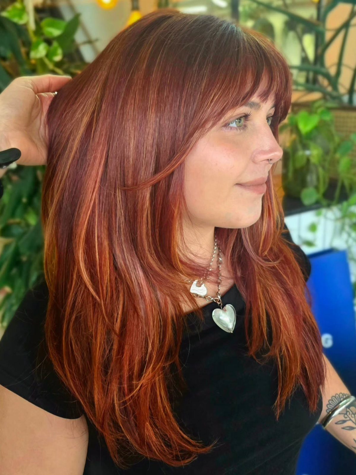 Dark copper hair with brighter amber face-framing sections in a salon