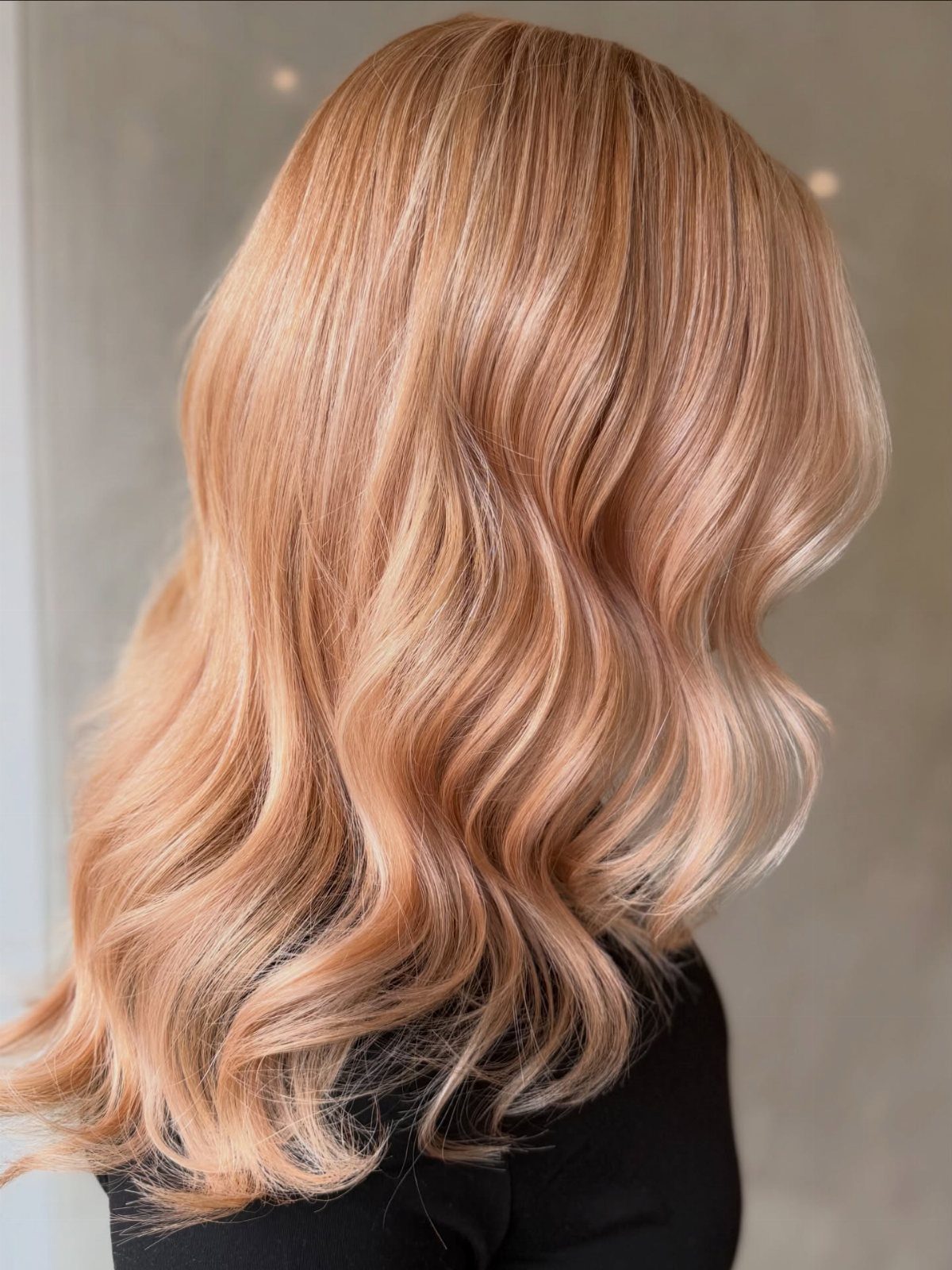 Wavy strawberry-blonde hair with pale pearl highlights against a neutral background