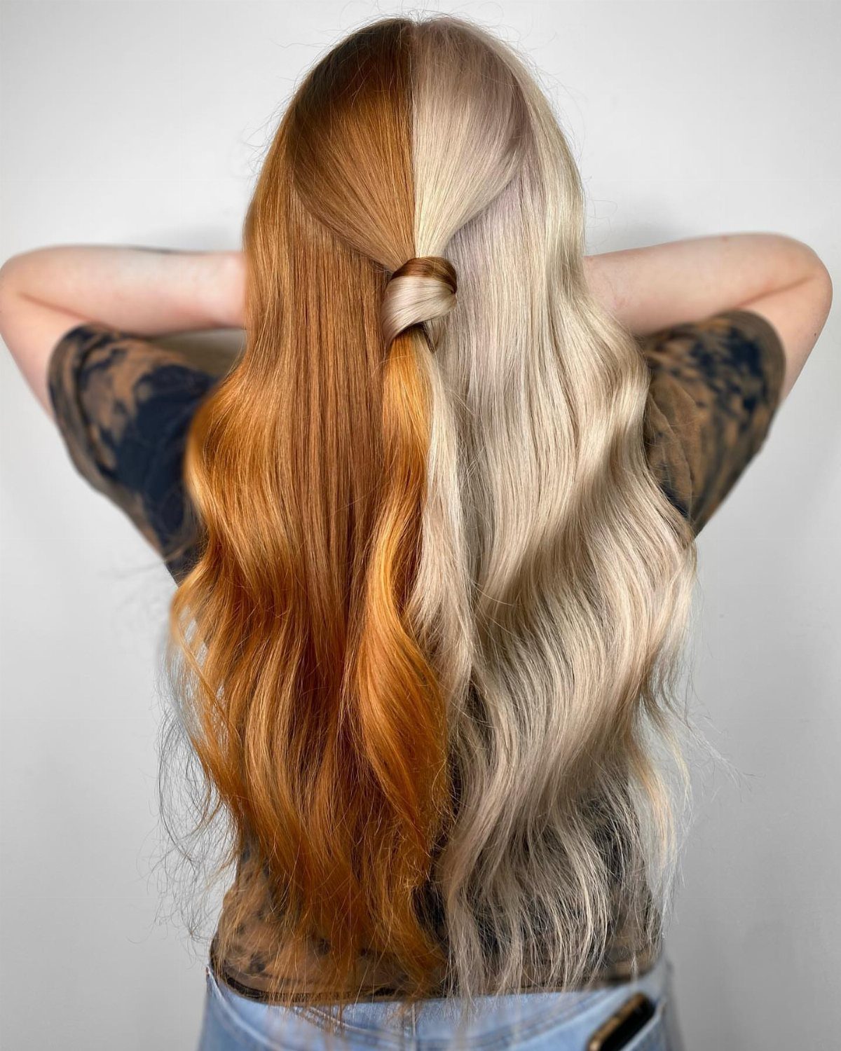 Long hair split into copper-red and pale blonde sections, tied near the crown