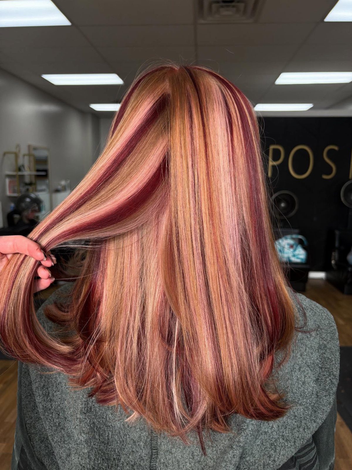 Long strawberry and auburn hair with blonde highlights and curled-under ends