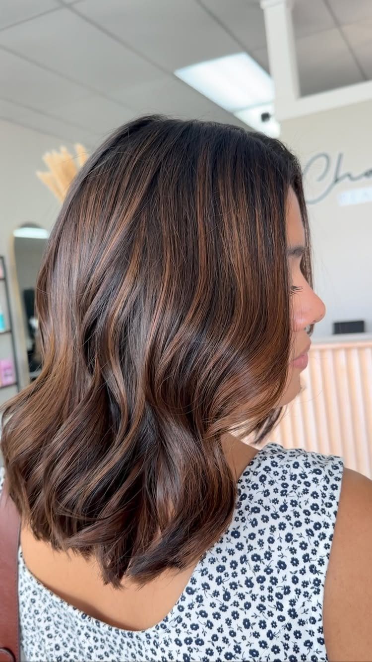 Short wavy brown hair with subtle lighter brown balayage highlights