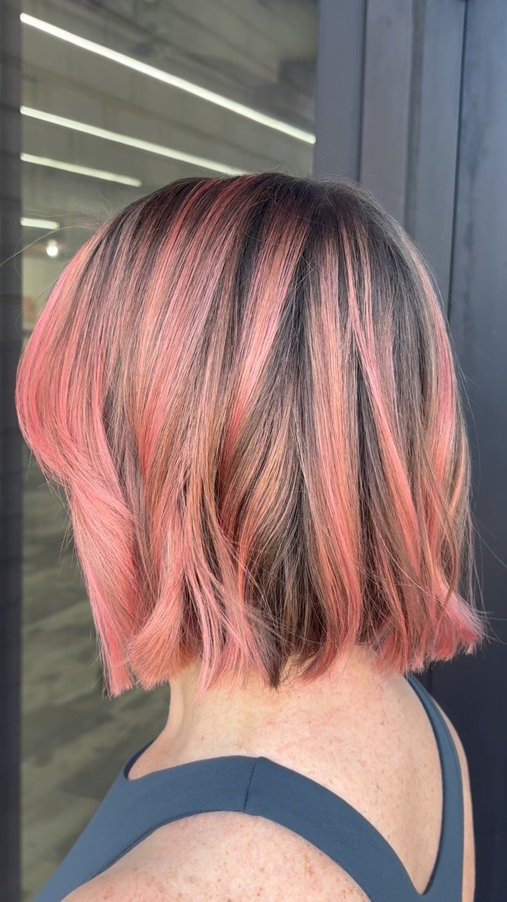 Short brown bob with vivid pink balayage highlights through the ends