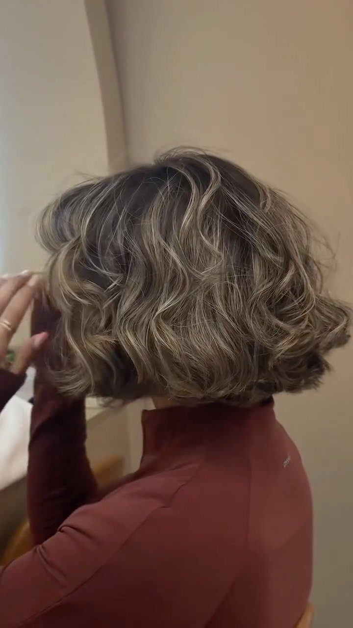 Short wavy brown hair with soft ash-blonde balayage highlights