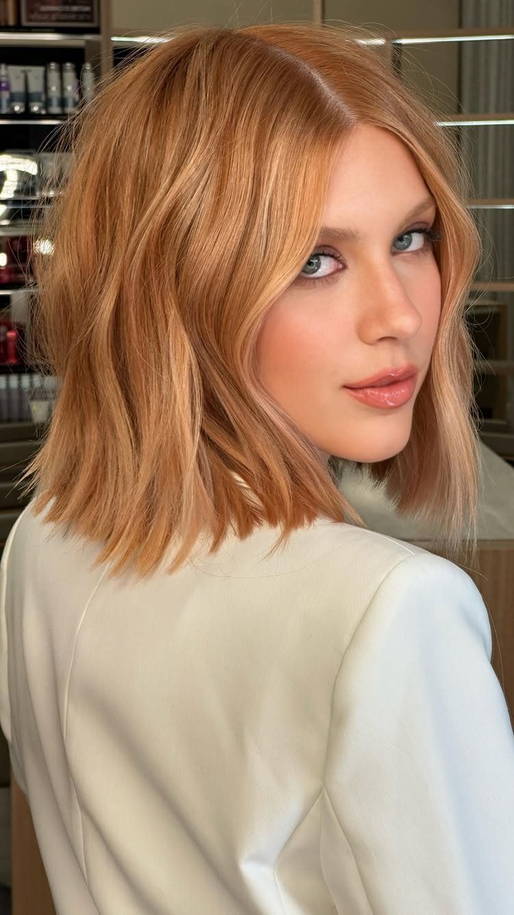 Woman showing softly waved peach-blonde hair in a salon