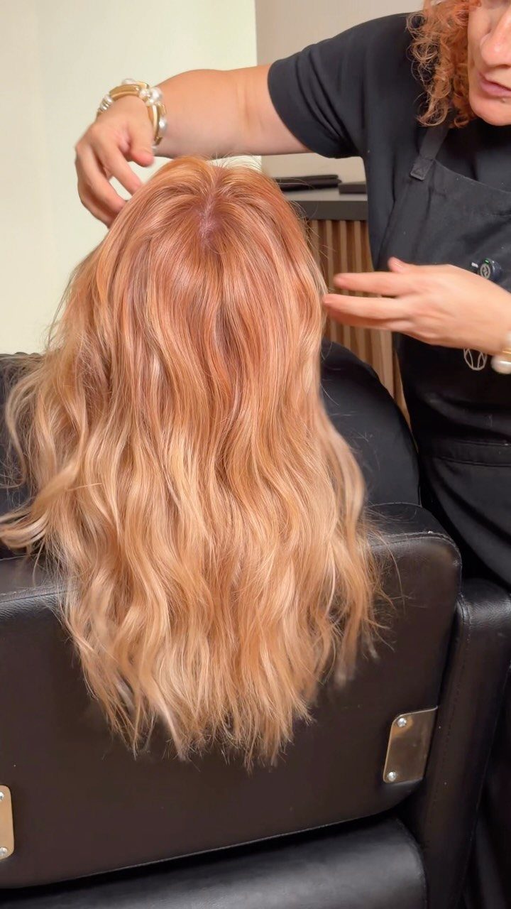 Long wavy tangerine strawberry blonde hair with warm pink and orange tones